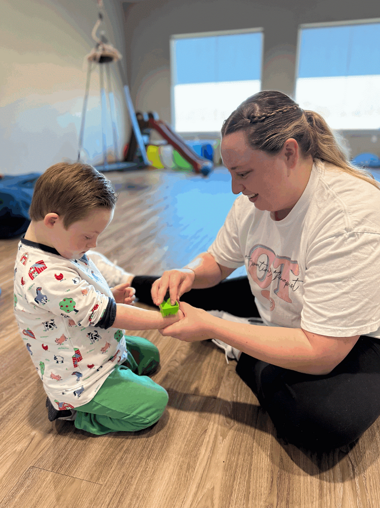 A therapist and child engaged in a sensory activity with therapeutic tools