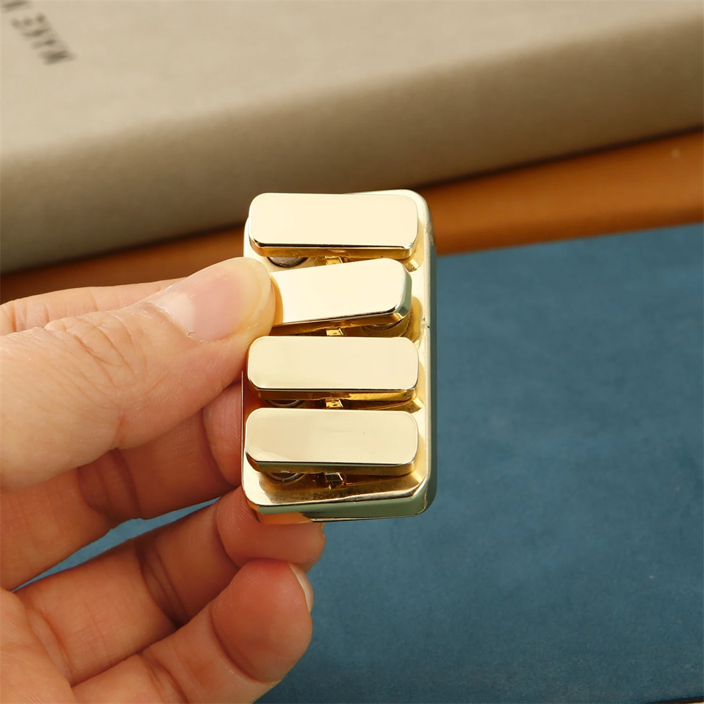 Close-up of a hand holding a machined brass fidget slider, showcasing its texture and weight