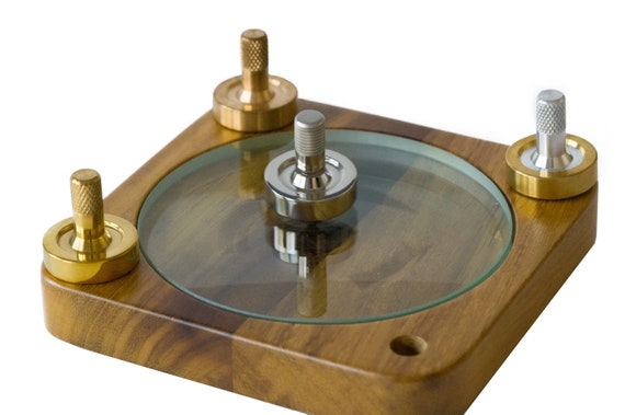 A high-end titanium fidget spinner with a sleek design, resting on a wooden table