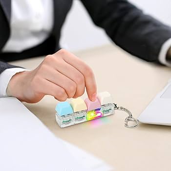 A person typing on a small, colorful mechanical keyboard fidget toy