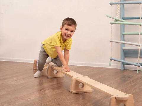 A child walking on a balance beam or balance board, focusing intently