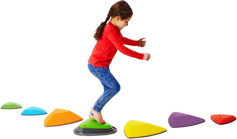 A child carefully stepping on colorful, sturdy Gonge Riverstones placed on the floor
