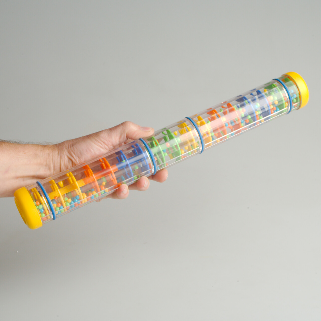 Noise-canceling headphones and a wooden rainmaker toy on a table