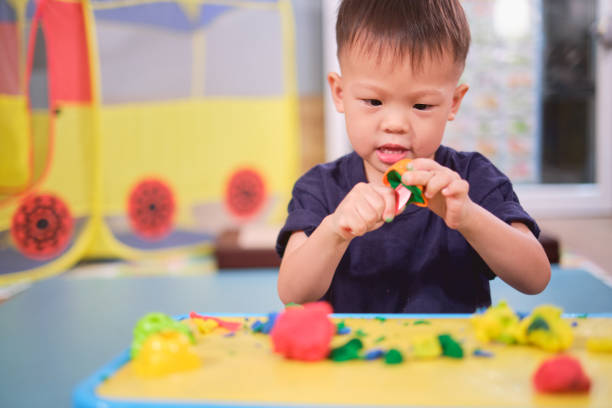 Toddler hands playing with colorful playdough